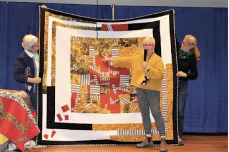 Jo Allbutt presenting a quilt during a trunk show