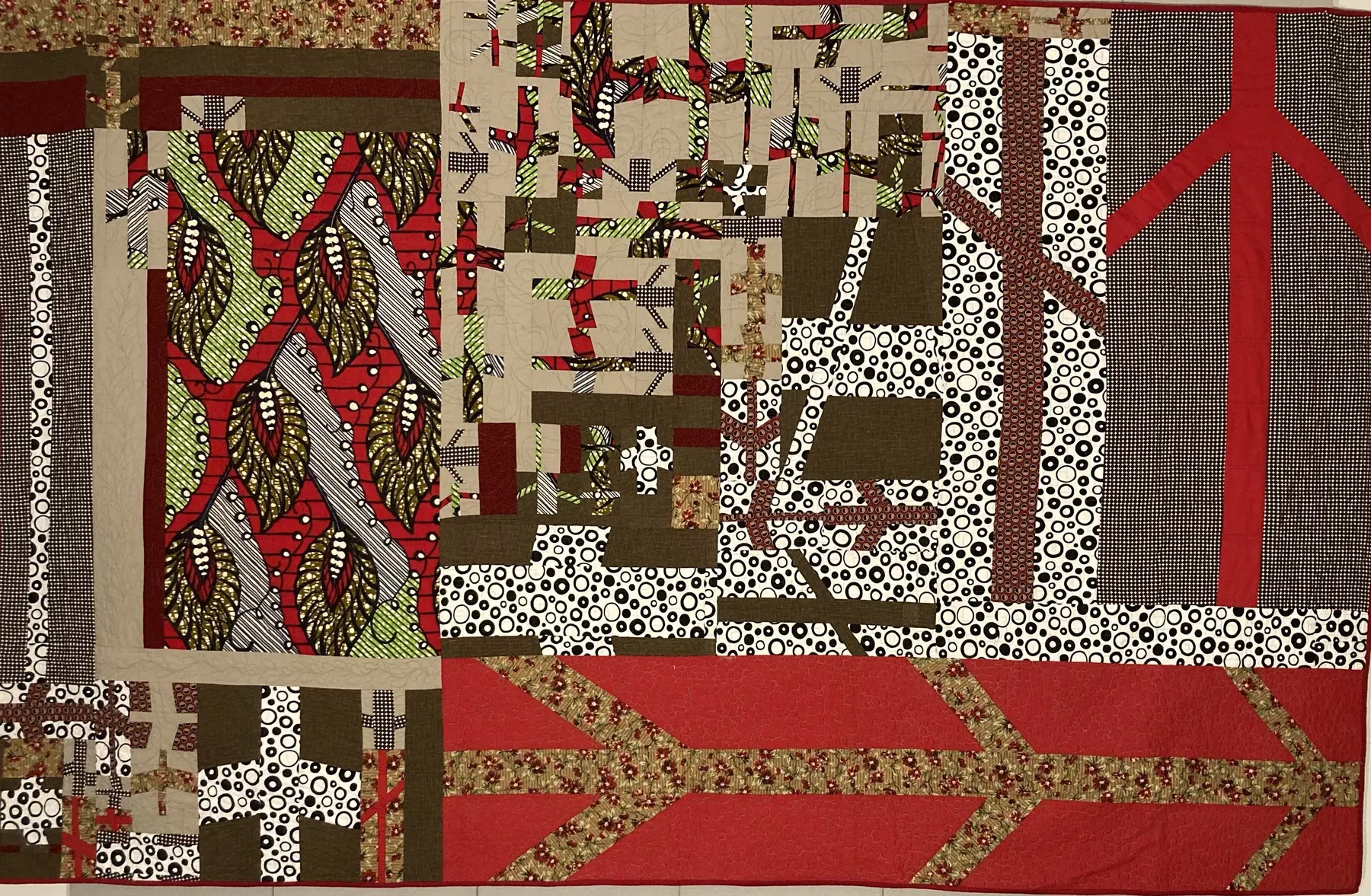 Horizontal art quilt with red, green, black and white improvised bands and loops