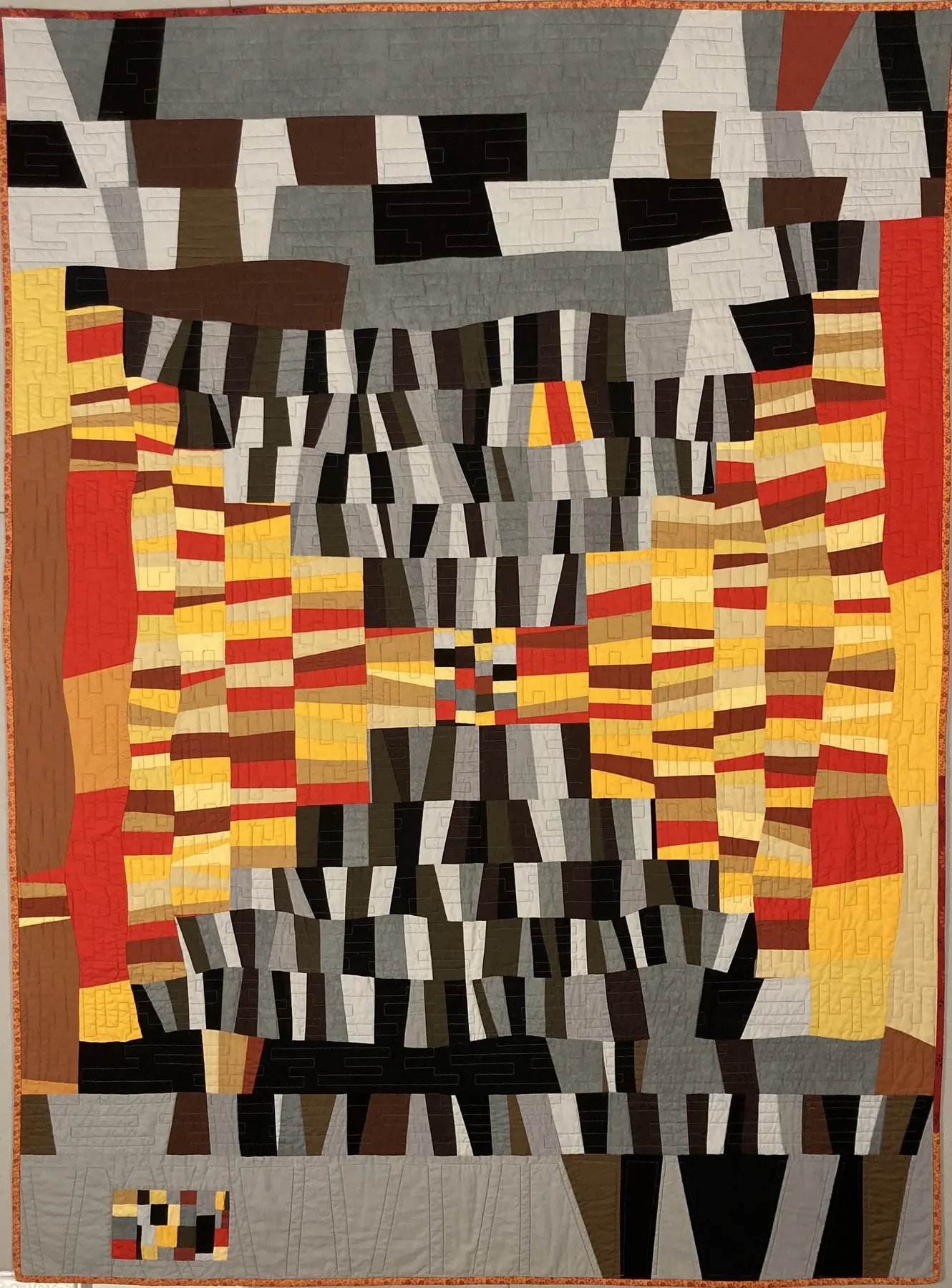 Art quilt with stacked black, white, yellow and red bands forming an abstract stepped composition