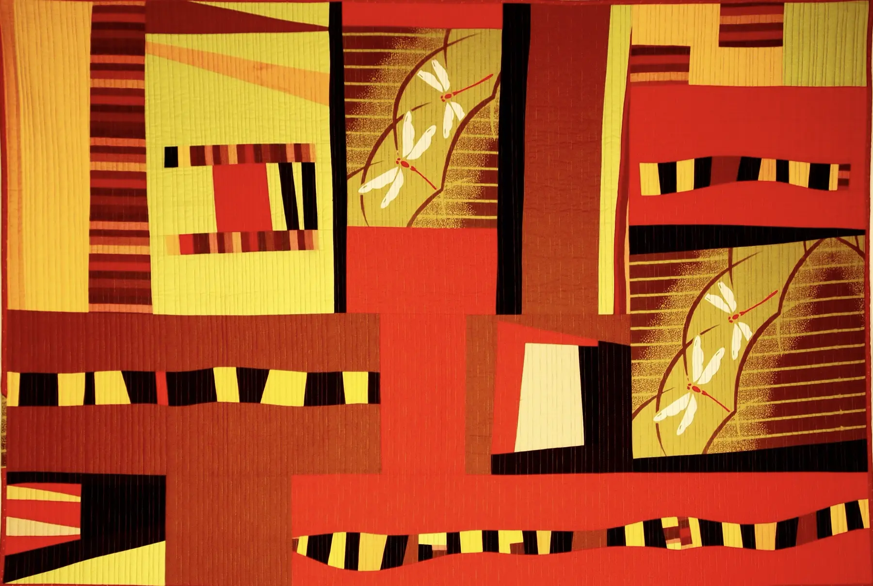 Red, orange and gold art quilt crossed by strong black linear forms