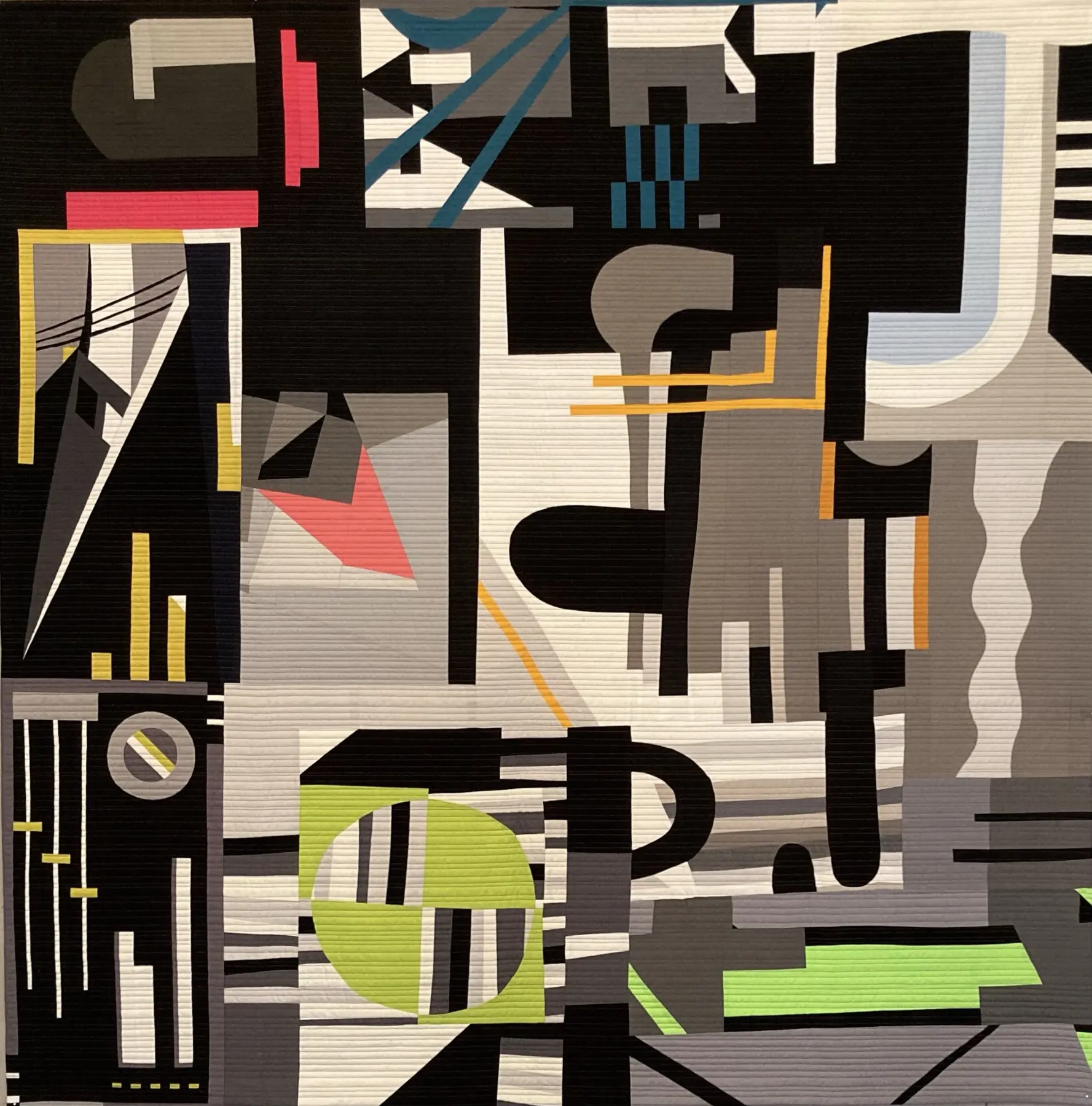 Black art quilt with bold white, pink, blue, yellow and green geometric forms